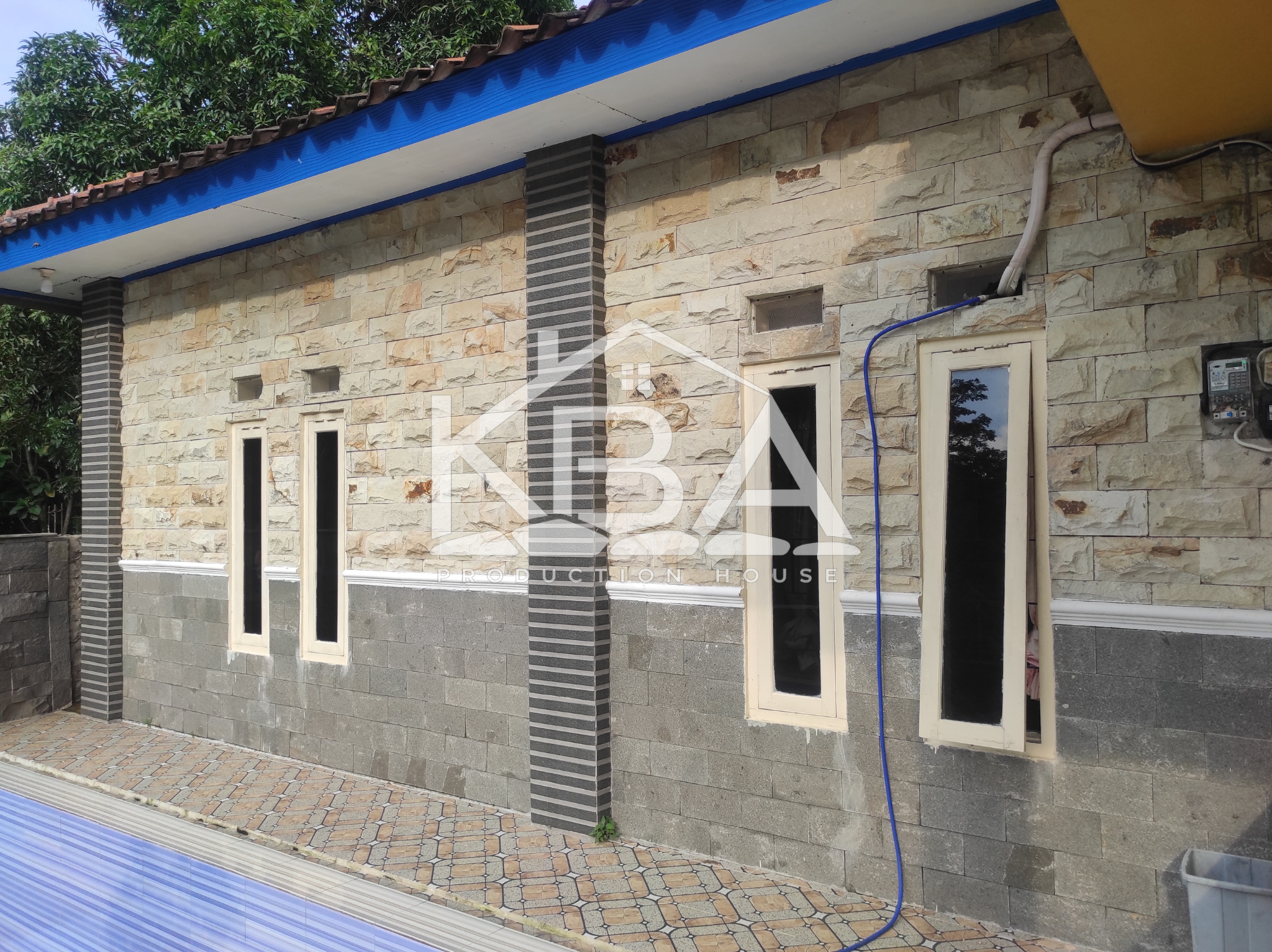 Pemasangan batu alam pada dinding rumah