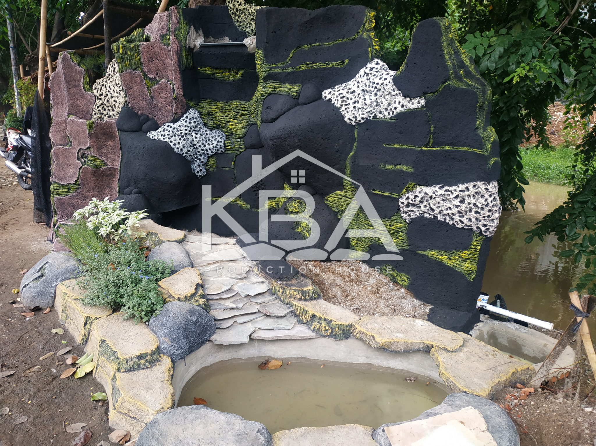 Pembuatan relief batu alam pada kolam ikan